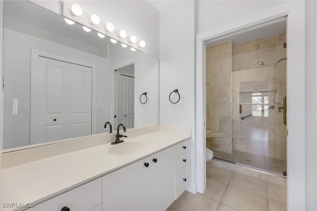 bathroom featuring vanity, tile patterned floors, a shower with door, and toilet