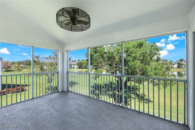 unfurnished sunroom with vaulted ceiling, a water view, and plenty of natural light