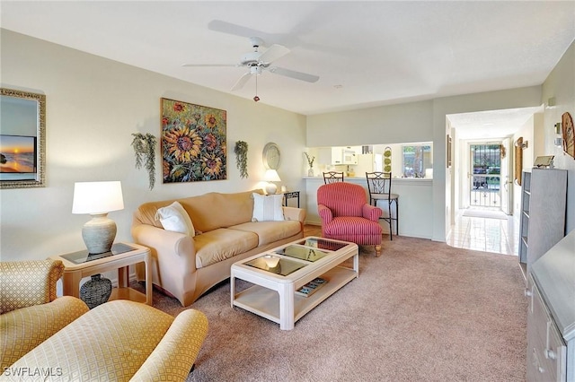 carpeted living area with ceiling fan