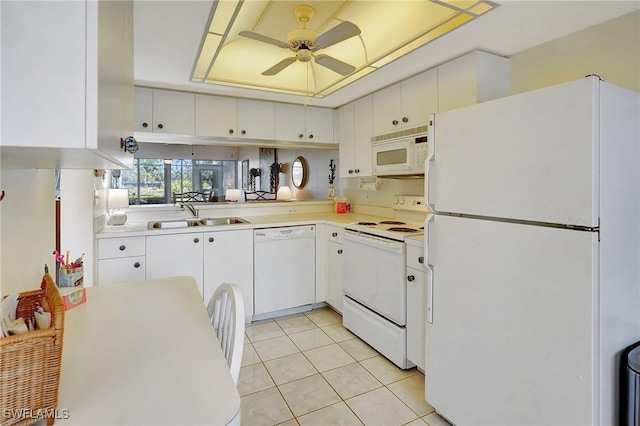 kitchen featuring white cabinetry, sink, light tile patterned floors, a tray ceiling, and white appliances