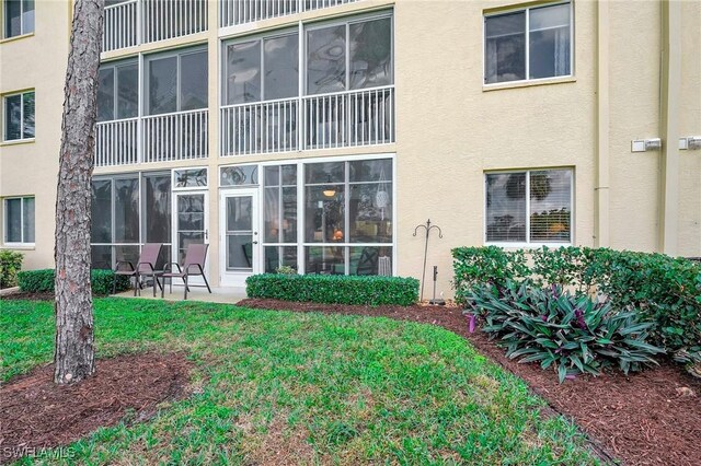 rear view of property featuring a patio and a lawn