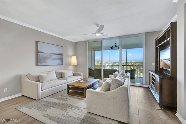 living room with wood finished floors, a ceiling fan, baseboards, ornamental molding, and floor to ceiling windows