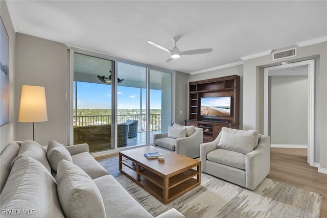 living room with baseboards, visible vents, ornamental molding, wood finished floors, and floor to ceiling windows