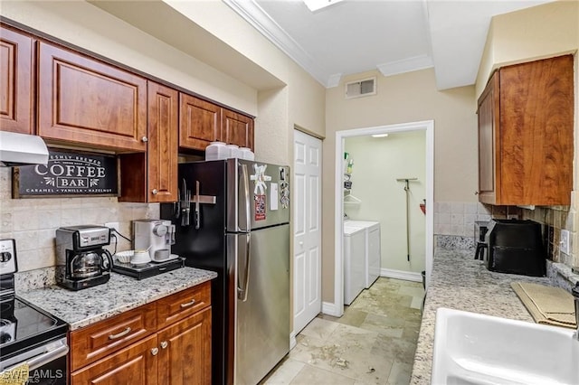 kitchen featuring sink, tasteful backsplash, washer and dryer, ornamental molding, and stainless steel appliances