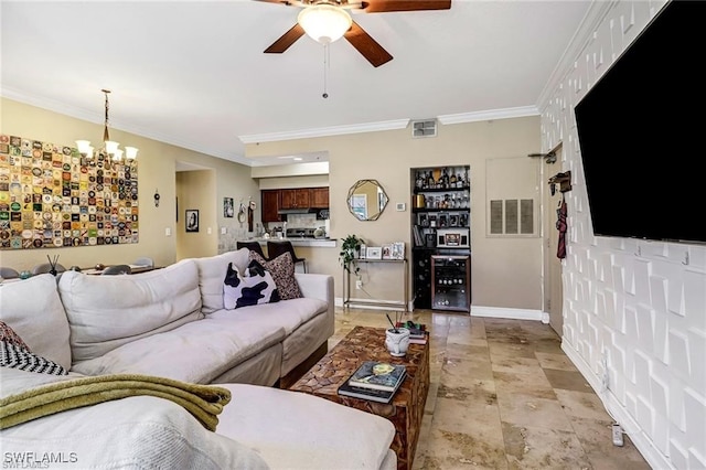 living room with ceiling fan with notable chandelier and ornamental molding