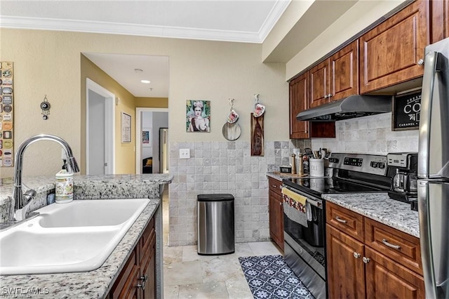 kitchen with sink, crown molding, tile walls, appliances with stainless steel finishes, and light stone countertops