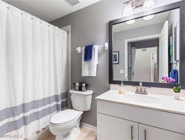 bathroom featuring vanity, tile patterned floors, and toilet