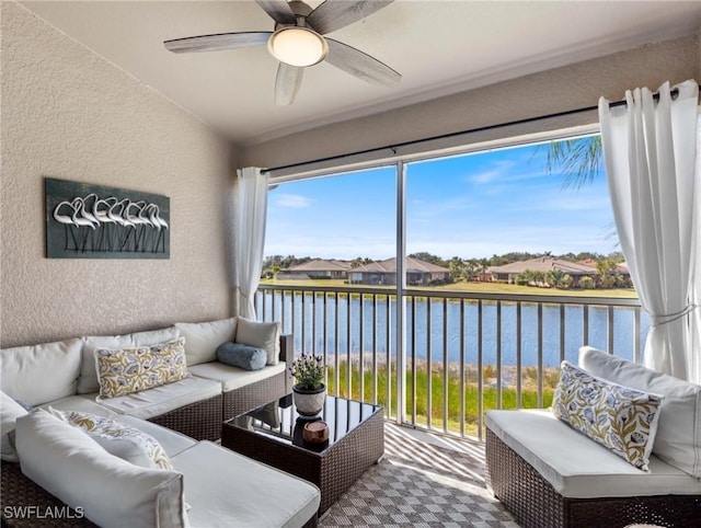 sunroom featuring a water view and a ceiling fan