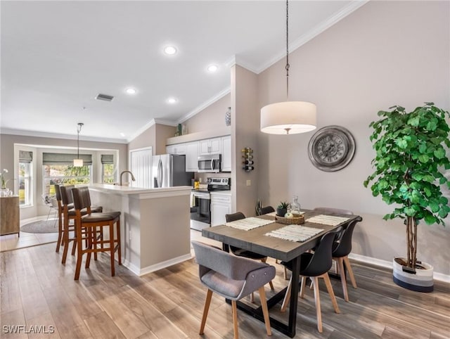 dining space with crown molding, high vaulted ceiling, and hardwood / wood-style flooring