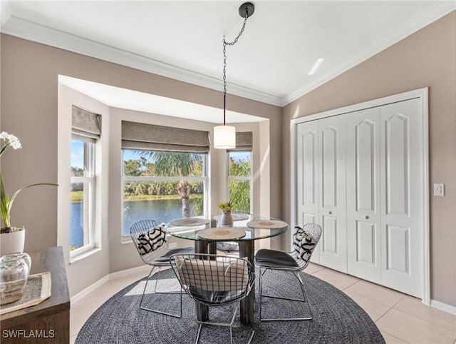 dining area featuring a water view, light tile patterned floors, baseboards, and ornamental molding