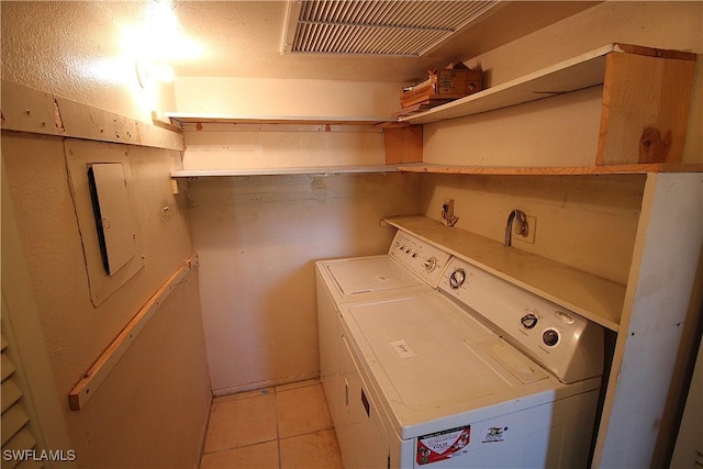 laundry area featuring light tile patterned floors and washer and clothes dryer