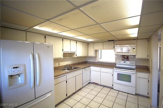 kitchen with sink, light tile patterned floors, a drop ceiling, and white appliances