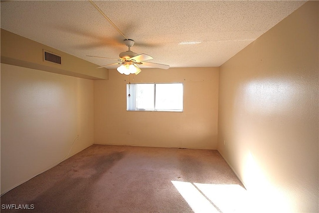 carpeted empty room with ceiling fan and a textured ceiling