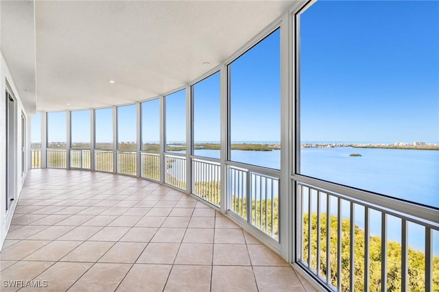 unfurnished sunroom featuring a water view