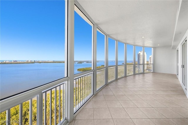 unfurnished sunroom with a water view