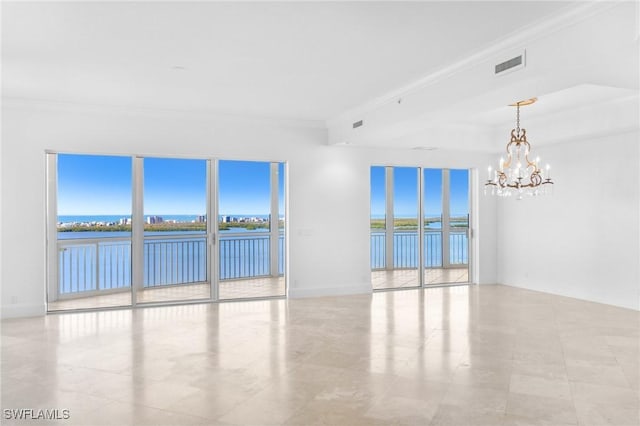 spare room featuring a notable chandelier, crown molding, and a water view