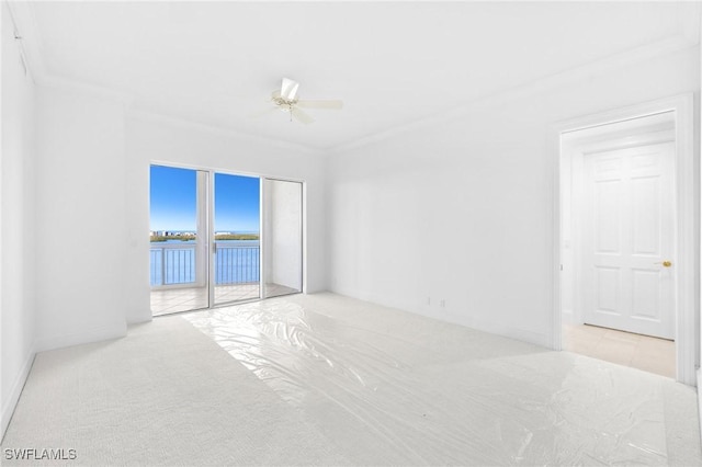 unfurnished room featuring a water view, ceiling fan, and crown molding