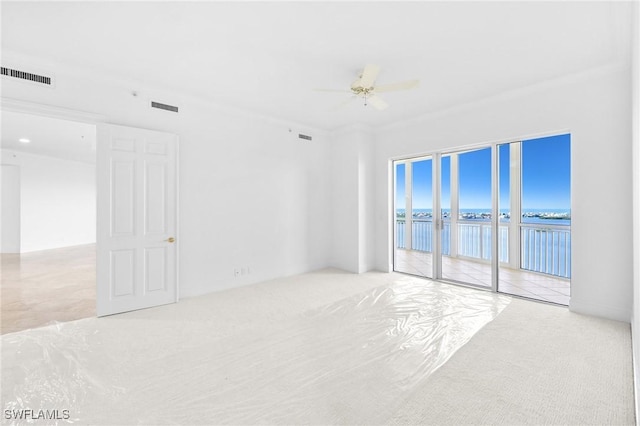 spare room featuring a water view and ceiling fan