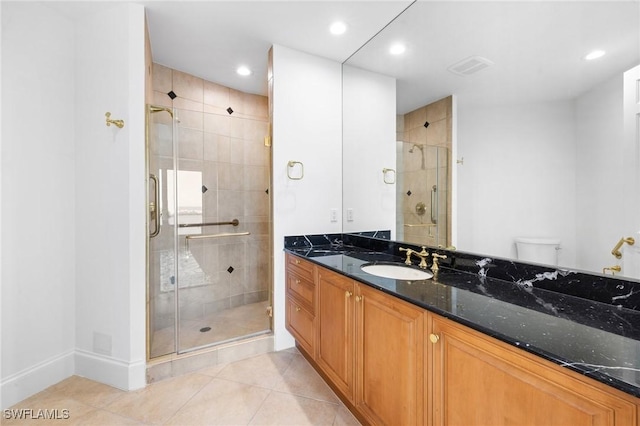 bathroom with vanity, tile patterned flooring, a shower with shower door, and toilet