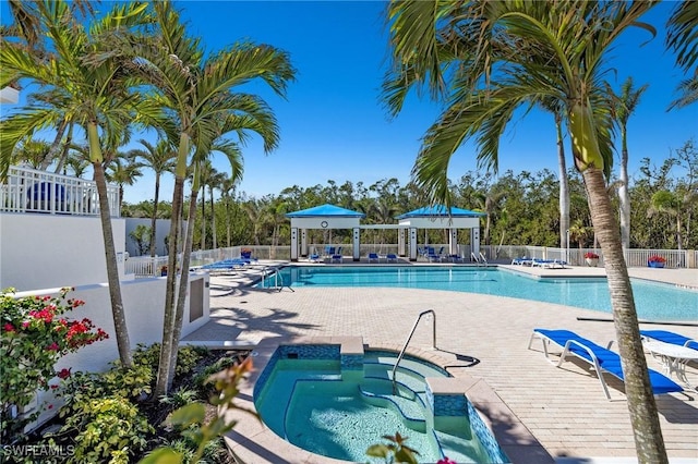 view of swimming pool with a hot tub and a patio area