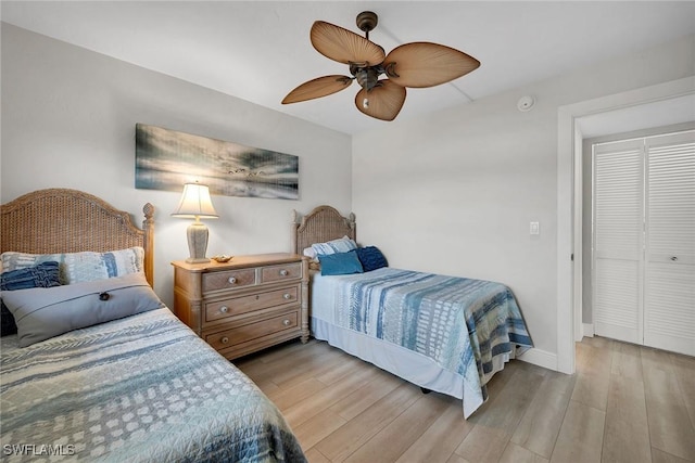 bedroom with light hardwood / wood-style floors, a closet, and ceiling fan