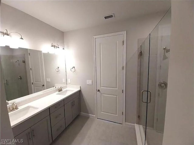 bathroom featuring vanity, an enclosed shower, and tile patterned flooring