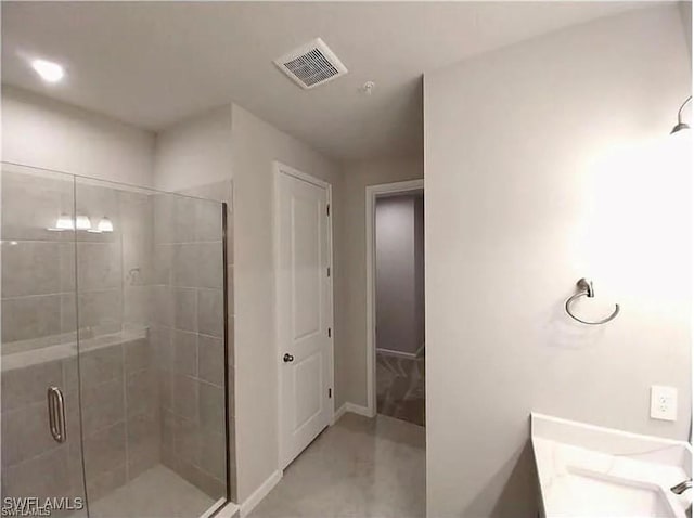 bathroom with a shower with door and vanity