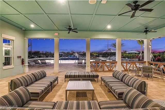 patio terrace at dusk with an outdoor hangout area and ceiling fan