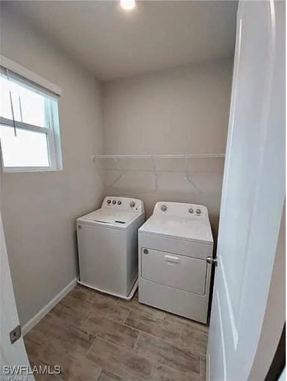 laundry room featuring washing machine and dryer and light hardwood / wood-style flooring