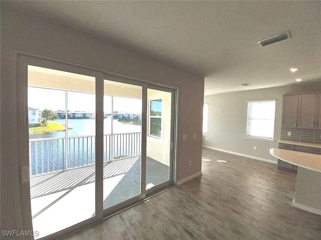 doorway featuring a water view and dark hardwood / wood-style floors