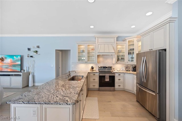 kitchen with sink, appliances with stainless steel finishes, light stone counters, custom exhaust hood, and kitchen peninsula