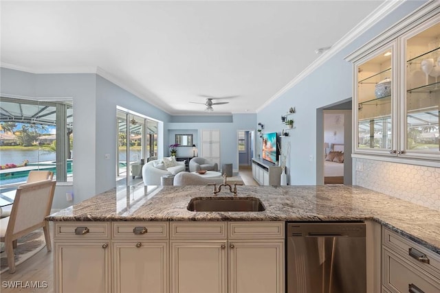 kitchen featuring light stone counters, sink, dishwasher, and a water view