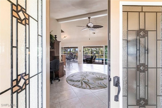 entrance foyer with ceiling fan, lofted ceiling with beams, and light tile patterned floors