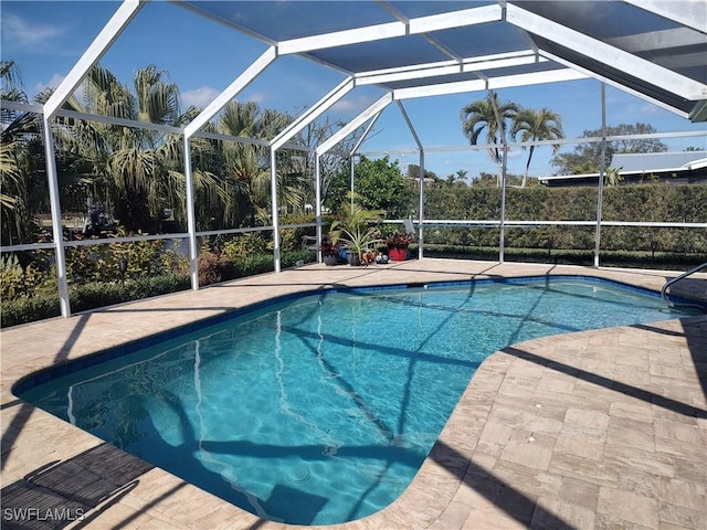 view of swimming pool featuring a lanai and a patio area