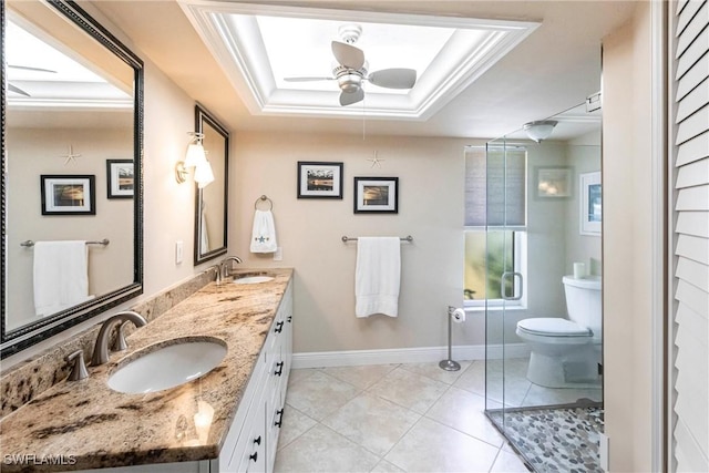 bathroom featuring tile patterned floors, toilet, vanity, a tray ceiling, and ceiling fan