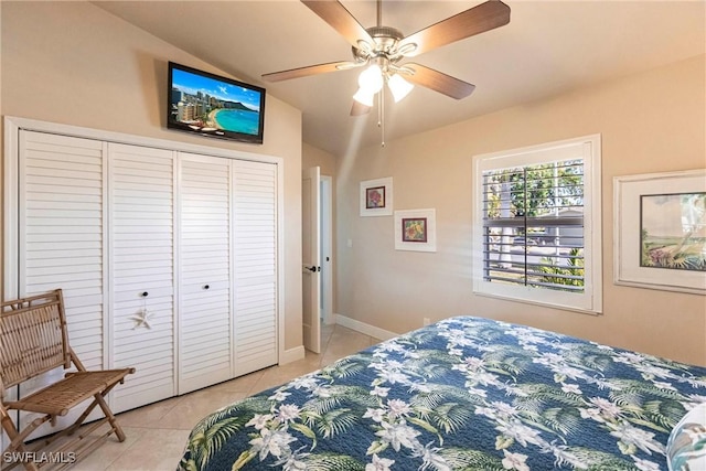 bedroom featuring lofted ceiling, light tile patterned floors, ceiling fan, and a closet