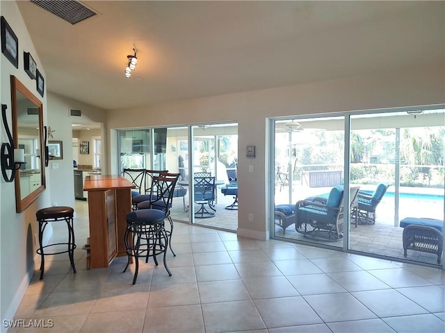 dining room with vaulted ceiling and light tile patterned floors