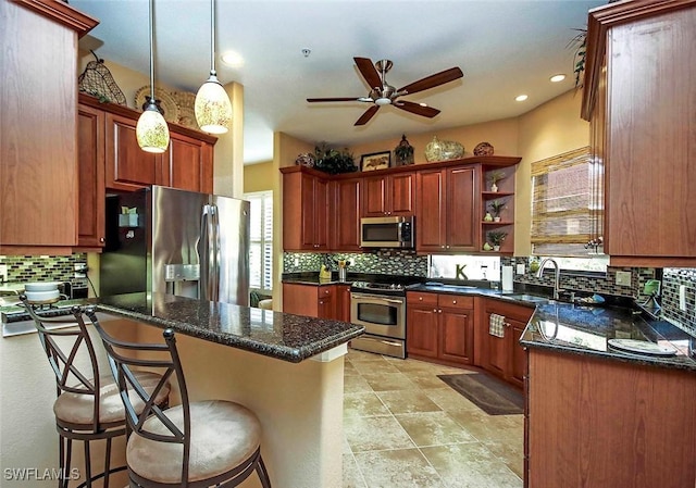 kitchen featuring appliances with stainless steel finishes, sink, a breakfast bar area, and decorative light fixtures