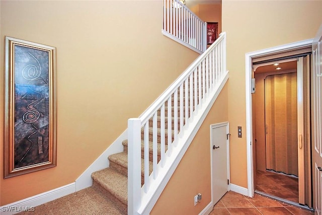 stairs with tile patterned flooring and a high ceiling