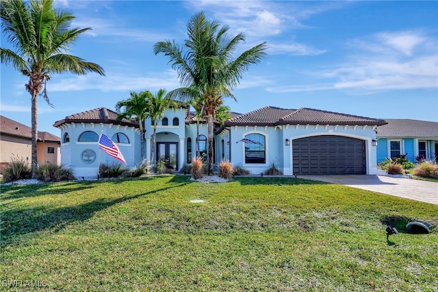 mediterranean / spanish home with a garage and a front lawn