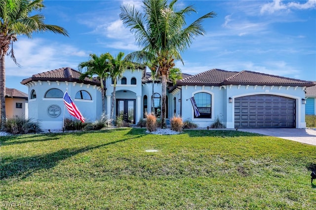 mediterranean / spanish house with a garage, a front yard, and french doors