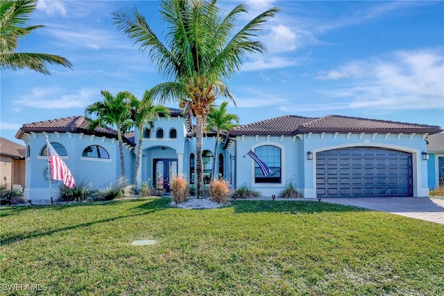 mediterranean / spanish house featuring a garage and a front yard