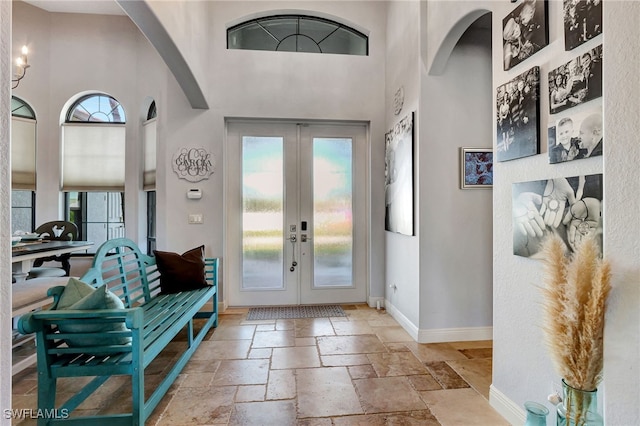 foyer featuring a towering ceiling and french doors