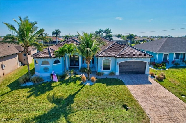 mediterranean / spanish home featuring a garage and a front yard