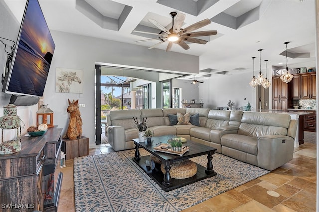 living room featuring coffered ceiling, ceiling fan with notable chandelier, and beamed ceiling