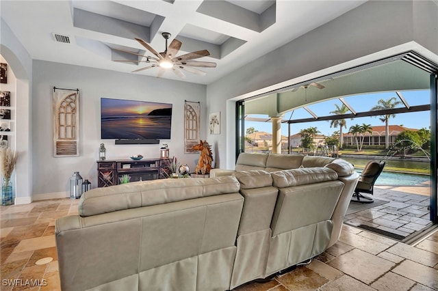 living room with beam ceiling, coffered ceiling, ceiling fan, and a towering ceiling