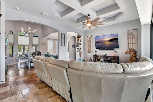 living room with coffered ceiling, ceiling fan with notable chandelier, and beamed ceiling