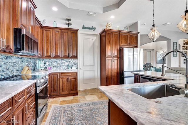 kitchen with tasteful backsplash, hanging light fixtures, sink, and appliances with stainless steel finishes