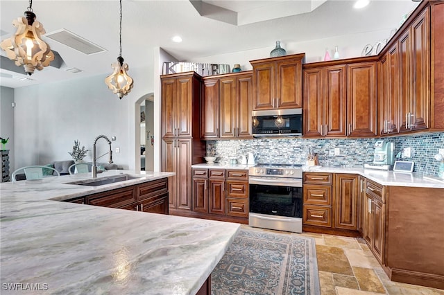 kitchen with stainless steel appliances, decorative light fixtures, sink, and backsplash