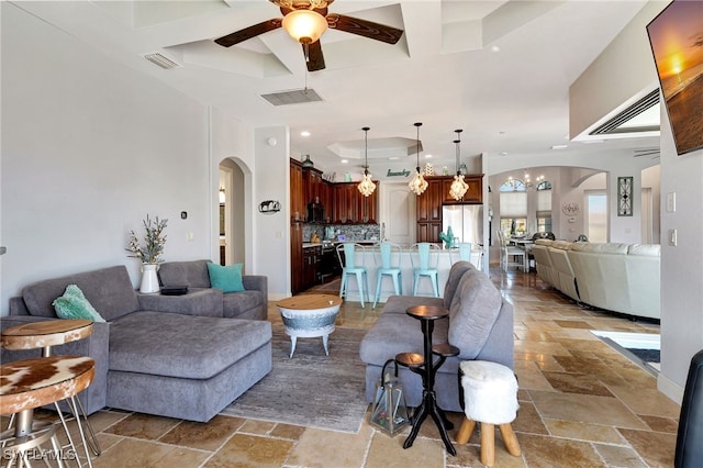 living room featuring a raised ceiling and ceiling fan